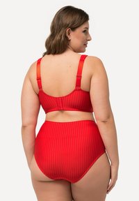 Bañador de cintura alta a rayas rojas con bralette a juego, que presenta tirantes ajustables y una textura suave. Diseñado para comodidad y ajuste.