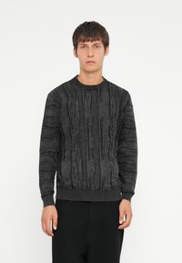 Knitted black sweater with textured vertical lines and ribbed cuffs and hem. Features a crew neckline, made from soft material.