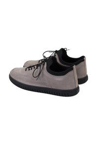 Graue Wildledersneaker mit schwarzen Akzenten, runder Zehenpartie, Schnürung vorne und strukturiertem schwarzen Gummisohle, mit minimalen Nähdetails.