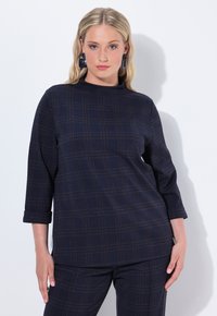 Top a scacchi blu navy con collo alto, maniche a tre quarti e morbida texture, caratterizzato da un sottile motivo a linee marroni.