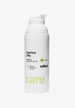 Witte cilindrische fles met een pompdispenser. Het etiket bevat groene tekst en zwarte accenten, met aanduiding SPF 50, niacinamide en zink PCA.