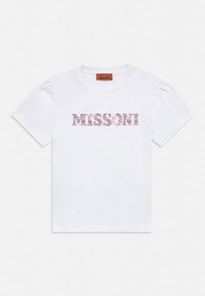 Valge lühikeste varrukatega T-särk puffy õlgadega ja mustrilise kujundusega "MISSONI" tekst rinnal keskel.