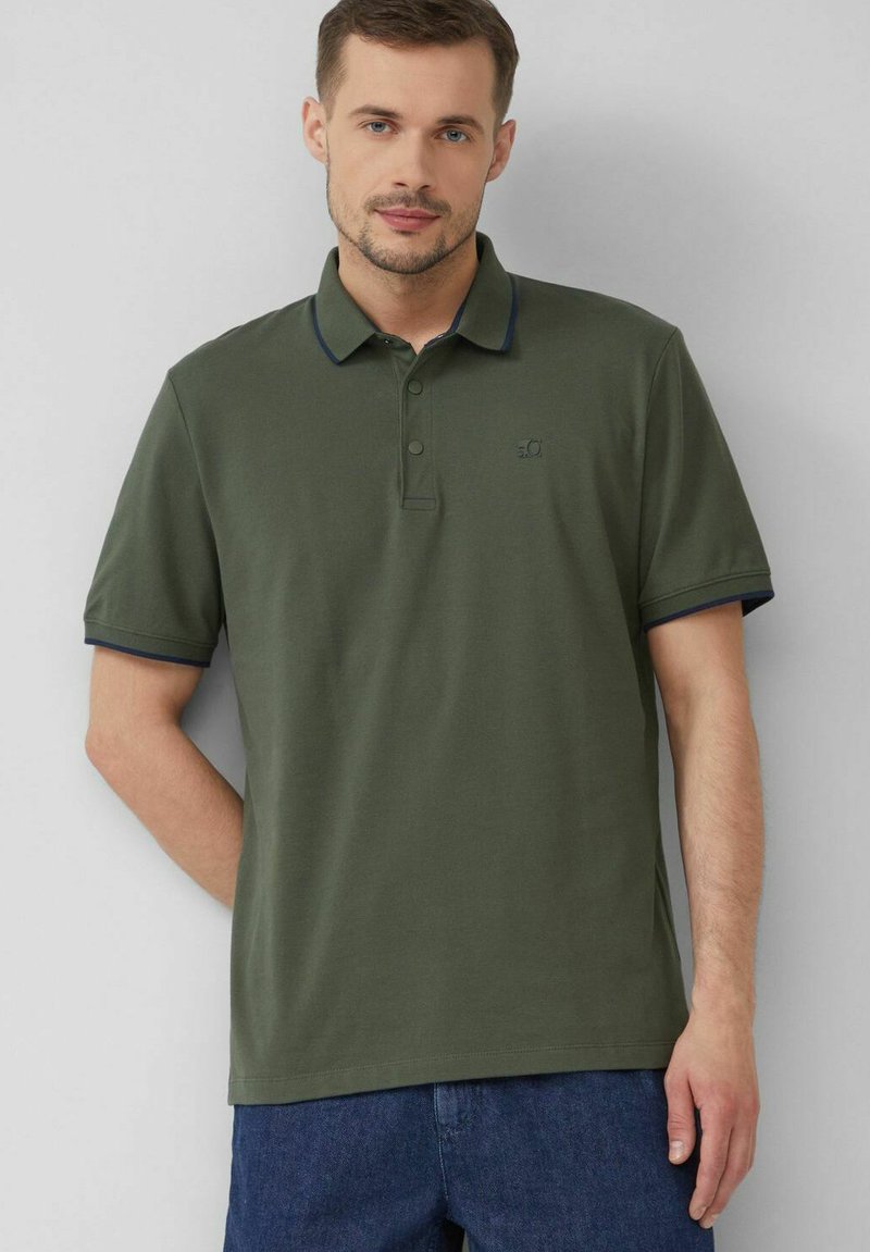 Olivengrünes Polo-Shirt aus Baumwolle mit kurzen Ärmeln, kontrastierendem marineblauen Kragen und Ärmeln und einem kleinen Logo auf der Brust.