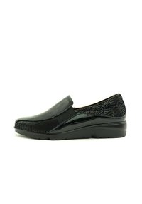 Zapatos negros sin cordones con parte superior de cuero brillante y trasera con patrón texturizado. Presentan una puntera redonda y una cómoda suela de goma.