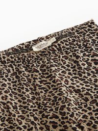 Legginsy w cętki lamparta z beżowym tłem i czarnymi oraz brązowymi plamami. Elastyczny pasek w talii z metką oznaczoną "MarMar Copenhagen".