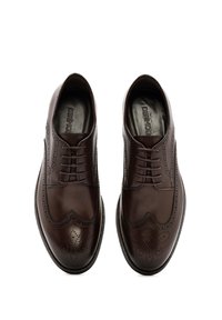 Chaussures Derby en cuir marron avec design à bouts perforés, présentant des perforations décoratives et une texture lisse, accentuées par des lacets et des semelles plates.