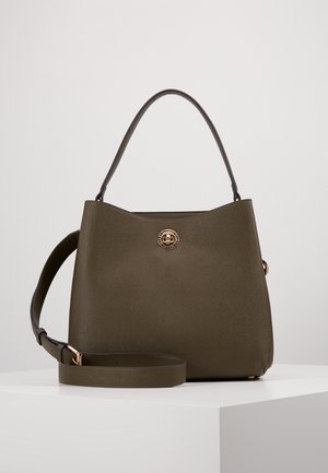 Sac à main structuré vert olive foncé avec une anse unique sur le dessus, une bandoulière ajustable et un fermoir rond en or à l'avant.