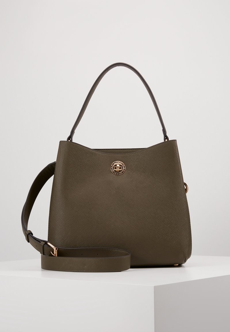 Sac à main structuré vert olive foncé avec une anse unique sur le dessus, une bandoulière ajustable et un fermoir rond en or à l'avant.