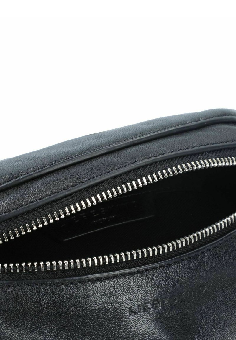 Schwarze Lederhandtasche mit einem Reißverschluss oben. Sie hat eine strukturierte Oberfläche und silberne Reißverschlussbeschläge, die den Markennamen innen anzeigen.