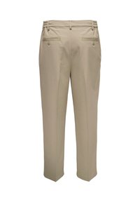Pantalon beige à texture lisse, présentant une coupe ajustée, une ceinture élastique froncée et deux poches arrière avec fermetures à boutons.