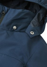Giacca blu navy con cappuccio, caratterizzata da una texture liscia, chiusura con zip e hardware in argento per regolare il colletto e il cappuccio.