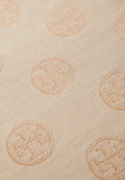 Μπεζ ύφασμα με υφασμάτινο σχέδιο που περιλαμβάνει κυκλικά μοτίβα σε πιο ανοιχτή απόχρωση. Κάθε μοτίβο περιέχει περίπλοκες γραμμικές σχεδιάσεις.