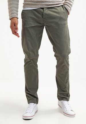 Gröna lätta chinos med rak bendesign, som har framfickor och är matchade med vita sneakers. Släta texturerade tyget.