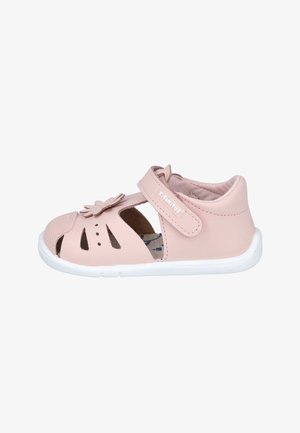 Sandalía rosa para niño pequeño con talón cerrado, recortes de punta abierta, decoración de flores y correa ajustable de Velcro sobre suela blanca.