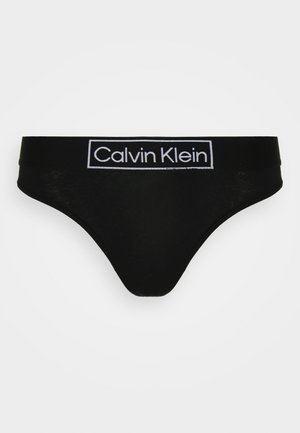 Black Calvin Klein thong with a soft fabric, featuring a wide elastic waistband embossed with the brand name in white.