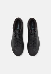 Black athletic shoes with a textured upper, featuring a herringbone pattern, black laces, and a subtle blue Nike logo on the side.