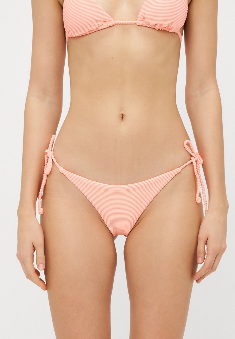 Rosa randig bikini med en triangulär topp och låg midja med justerbara sidoförbindelser, tillverkad av ett slätt tyg.