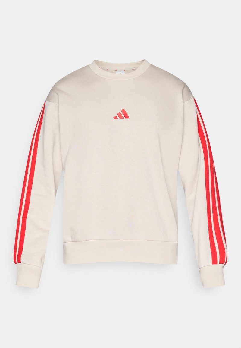 Beige sweatshirt met lange mouwen, voorzien van rode drie-strepen details op de mouwen en een klein rood Adidas-logo gecentreerd op de borst.