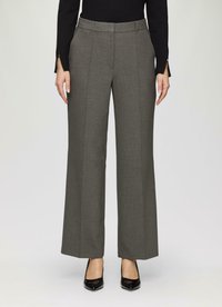 Pantalons gris sur mesure à jambes larges avec une texture lisse, présentant des plis avant et un détail de ceinture, associés à des talons hauts noirs.