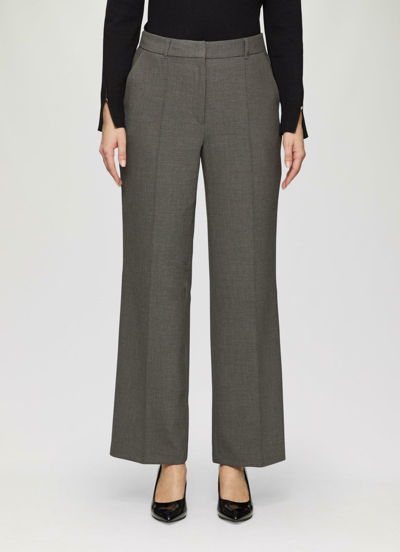 Pantalons gris sur mesure à jambes larges avec une texture lisse, présentant des plis avant et un détail de ceinture, associés à des talons hauts noirs.