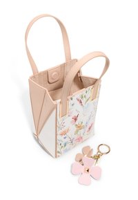 Mała torba na ramię z kwiecistym wzorem na białym tle, różowe sztucznej skóry boki, złote akcenty i dwa górne uchwyty. Wisiorek z kwiatowymi charmsami w odcieniu różowym.