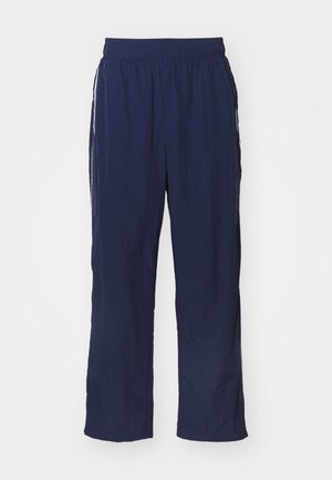 Calças leves azul-marinho com uma cintura elástica, corte descontraído, bolsos laterais e riscas brancas contrastantes nas laterais.