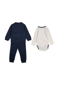 Mörkblå bomullssweatshirt och byxor med ribbade manschetter, tillsammans med en långärmad vit bodysuit med en mörkblå halsringning.