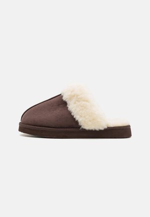 Brown suede slipper with a fluffy cream faux fur cuff, flat sole, and an open back design. Soft texture and rounded shape for comfort.