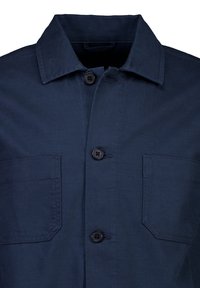 Camicia blu scuro con bottoni e colletto classico, caratterizzata da due tasche frontali e bottoni neri. Realizzata in tessuto strutturato.