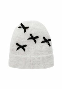 Bonnet en tricot blanc avec une texture douce, comportant cinq nœuds en tissu noir cousus sur la surface. Le design est rond et ajusté.