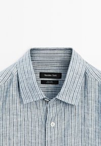 Blue and white vertically striped linen shirt collar with white button and Massimo Dutti brand label inside.
