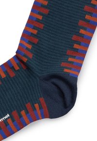 Calcetín de colores con un patrón que presenta rayas horizontales en azul, naranja y rojo. El material parece suave y tiene una textura acanalada en verde oscuro.