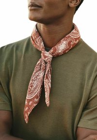 Brun paisley-mønsteret tørklæde, lavet af letvægtsstof, bundet om halsen over en olivengrøn skjorte, hvilket tilføjer tekstur og detaljer.