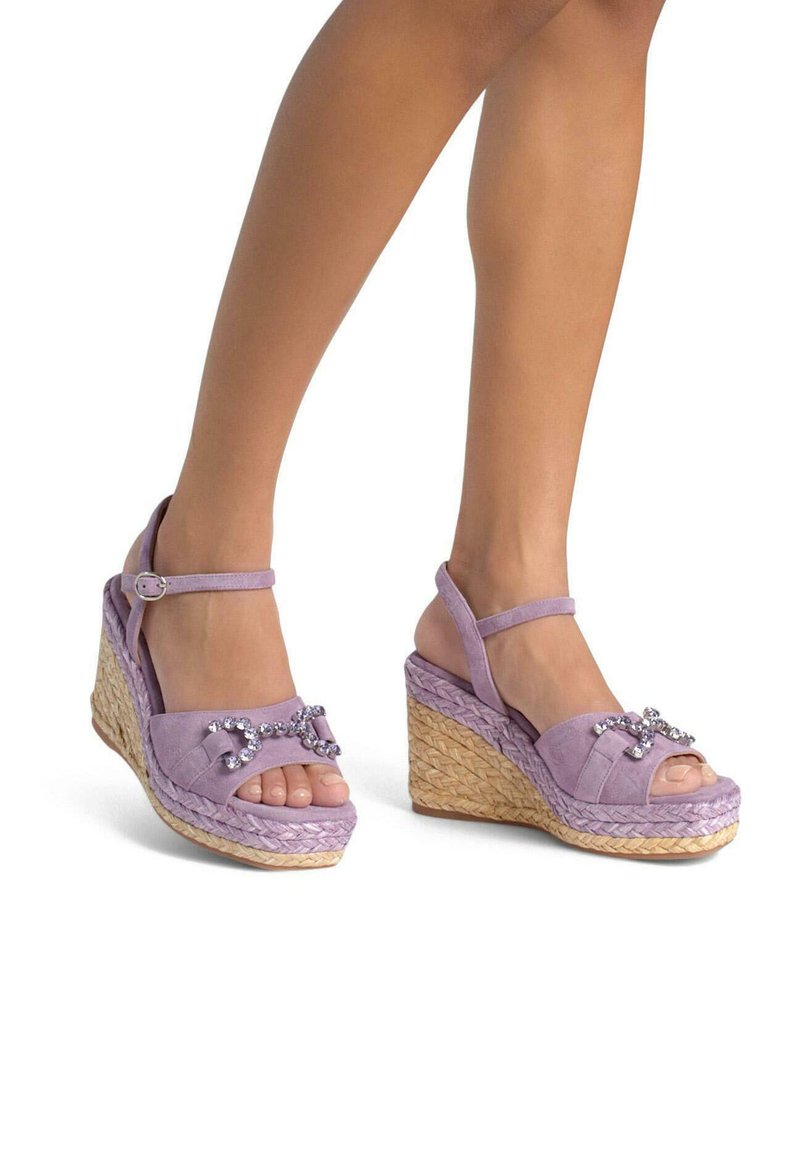 Lavendel suède wedge sandaal met open teen, enkelbandje, geweven raffia zool en strassteenaccenten aan de voorkant.