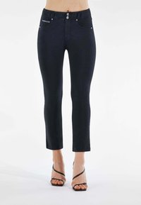 Mustat farkkulegginsit, joissa on keski-korkea vyötär ö, kolme etupainiketta ja viisi taskua, viimeistelty brändilogolla etutaskussa.