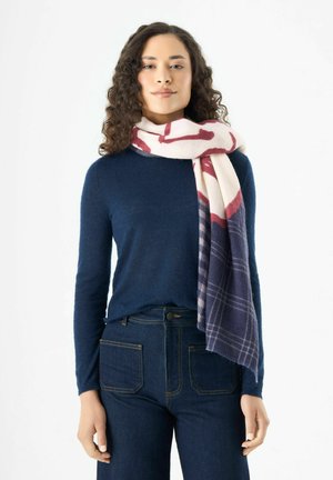 Pull en laine bleu marine associé à une grande écharpe à motifs dans des nuances de rose et bleu marine, avec une texture lisse et des bords à franges. Jean en denim avec poches.