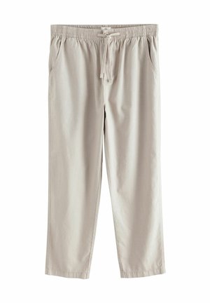 Helle beige Hose mit elastischem Bund, Kordelzug, Seitentaschen und geradem Bein, vor weißem Hintergrund dargestellt.