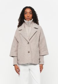 Veste en mélange de laine gris cendré avec des manches larges 3/4, un col à revers et deux boutons à l'avant. La couche intérieure possède une finition matelassée.