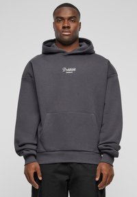 Grå hettegensere laget av en bomullsblanding. Har en kengurulomme og hvit brodert "Prohibited Garments" logo.