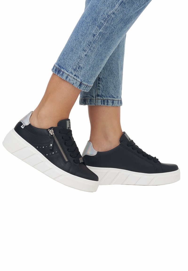 Schwarze Leder-Sneaker mit weißer Sohle, mit Schnürdesign und seitlichem Reißverschluss. Silberner Akzent an der Ferse und durchbrochene Details an der Seite.