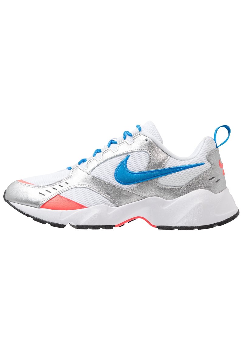 Baskets sportives Nike présentant un mélange de mesh blanc, d'accents argentés et de détails bleu vif. Elles ont une semelle blanche épaisse avec des reflets roses.
