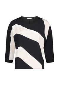 Zwart-crèmekleurig cropped topje met lange mouwen, voorzien van gedurfde zigzagpatronen en een gladde textuur. Ronde halslijn met contrastkleurige bies.