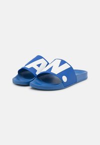 Blue slide sandals with a wide strap featuring large white lettering. Soft rubber material and textured footbed for comfort.