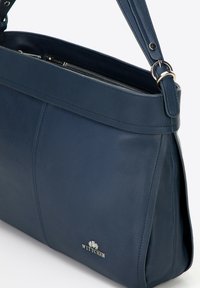 Navyfarbene Ledertasche mit glatter Textur, ausgestattet mit einem Reißverschluss, verstellbarem Trageriemen und einem silbernen WITTCHEN-Logo auf der Vorderseite.