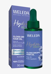 Olej do włosów Weleda Gloss Drops w zielonej szklanej butelce z kroplomierzem. Niebieskie opakowanie w pudełku z kwiatowym wzorem i szczegółami produktu. 30 ml.