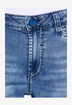 Blaue Jeans aus Denim mit einem Reißverschluss, einem blauen Knopf und weißen Nähten. Der Stoff hat eine ausgeblichene Optik und eine glatte Textur.