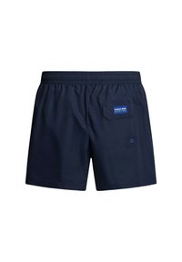Bañador de color azul marino con cinturilla elástica, que cuenta con un bolsillo trasero con parche de logo y un detalle circular. Tela suave y ligera.