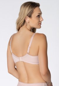 Różowy biustonosz z regulowanymi ramiączkami o gładkiej teksturze, z zapięciem na haczyk z tyłu i minimalistycznym wzornictwem.