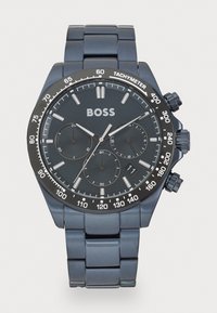 Μαύρο μέταλλο χρονογράφου ρολόι με σκούρο καντράν, ασημί λεπτομέρειες, ταχυμετρική κλίμακα και σχέδιο συνδεδεμένου βραχιολιού. Το όνομα μάρκας "BOSS" εμφανίζεται έντονα.