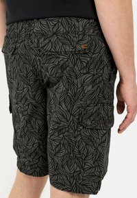 Cargo shorts in een donkergrijze stof met een intricaat zwart bladerenpatroon, meerdere zakken en een klein merklogo op de achterkant.